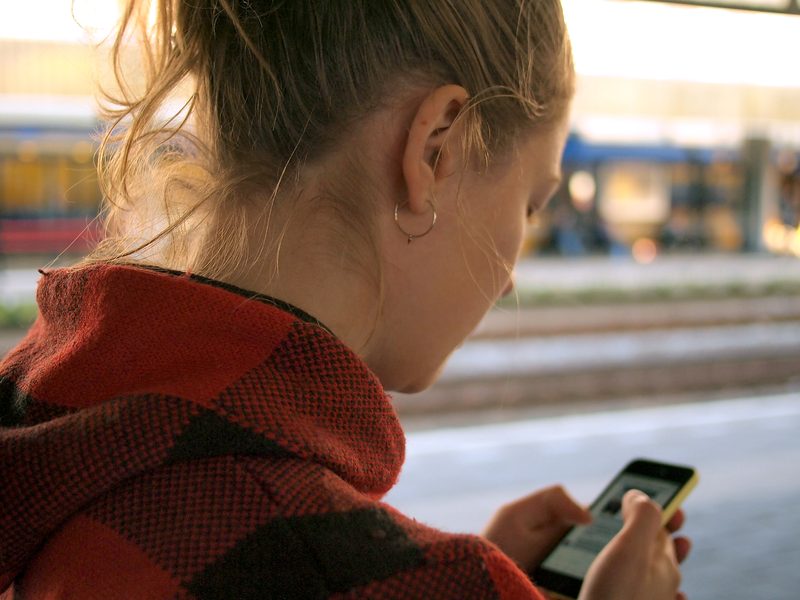 スマートフォンの画面を確認する人の後ろ姿